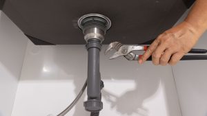 Plumber clearing clogged residential drain